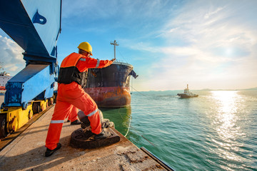 ship vessel is on leaving departure from the port terminal after completion of loading/discharging operation by gang of mooring attending at last party, tug boat standing by to safety assist towage