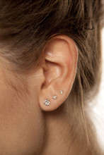Closeup Of Female Ear With Three Earrings