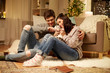 © Syda Productions - pets, hygge and people concept - happy couple with cat at home