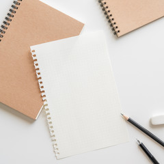Wall Mural - graph paper with spiral notebook, pencil and eraser on white background.