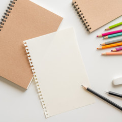 Wall Mural - blank paper with spiral notebook, pencil, eraser and color pencil on white background.