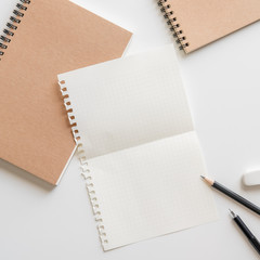 Wall Mural - fold graph paper with spiral notebook, pencil and eraser on white background.