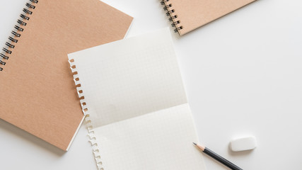 Wall Mural - fold graph paper with spiral notebook, pencil and eraser on white background.