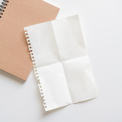 Wall Mural - fold graph paper with spiral notebook on white background.