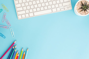 Wall Mural - flat lay photo of office desk with pencil and keyboard ,top view workpace on blue background and cop