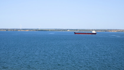 big transport ship in the sea wind generator on the background