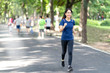 © ChayTee - Young attractive asian runner woman running in urban public nature park in city wearing blue or black sporty sportswear with copy space and sun light in morning walk or morning workout concept.