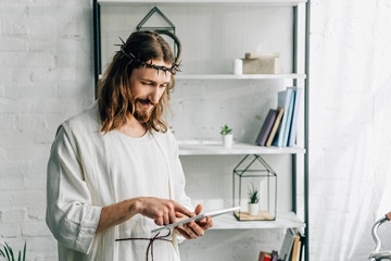 Poster - selective focus of Jesus in crown of thorns and robe using digital tablet at home