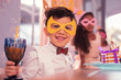 © zinkevych - Masquerade. Cheerful smiling boy feeling happy while being at the masquerade and drinking juice