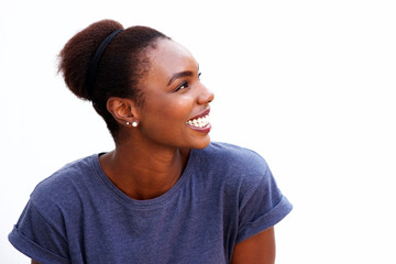 Close up happy young african woman smiling and looking away against isolated white background