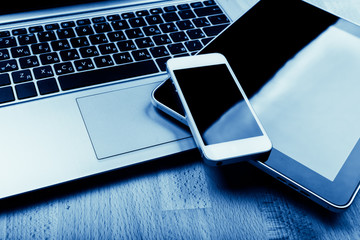 keyboard with phone and tablet pc on wooden desk