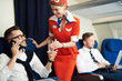 © Seventyfour - Portrait of smiling flight attendant serving glass sparkling water to handsome businessman enjoying first class trip, copy space
