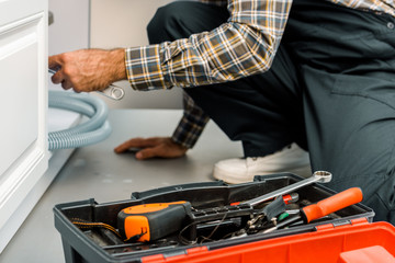 Wall Mural - cropped image of plumber repairing broken sink in kitchen