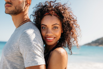 Smiling woman standing at the beach with her boyfriend