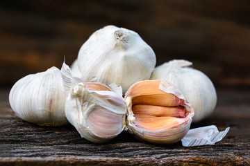 Garlic or Allium sativum L., white spices on brown woodden.