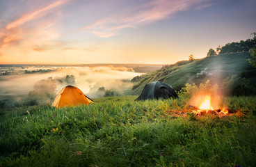 Wall Mural - orange tent and bonfire over misty river