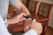 © DragonImages - Close-up image of doctor setting health application on smartwatch on wrist of senior patient