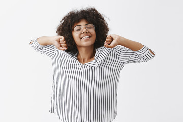 Wall Mural - waist-up shot of energetic cute african american female who slept well stretching hands and smiling 