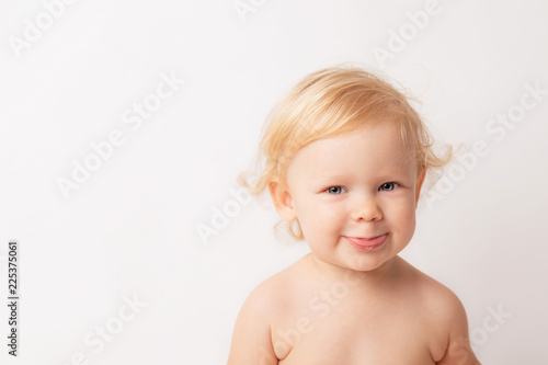 Portrait Of A Little Baby Girl With Blue Eyes And Curly Hair On A