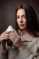 Poster - young beautiful woman with dark hair picked up holding a mug coffee with cream.