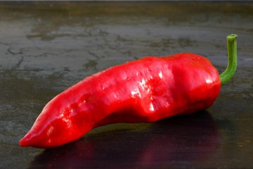 Fresh red hot pepper on dark background close up.