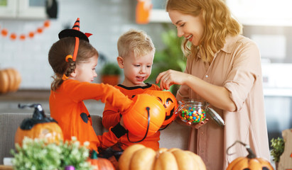 Wall Mural - happy Halloween! mother treats children with candy at home