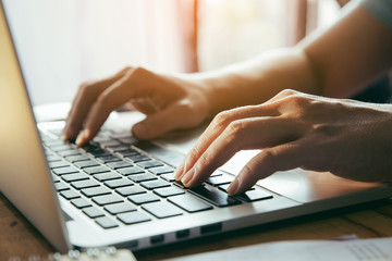 Close up fingers typing on the computer keyboard,pressing buttons, typing, simple close up with lens flare