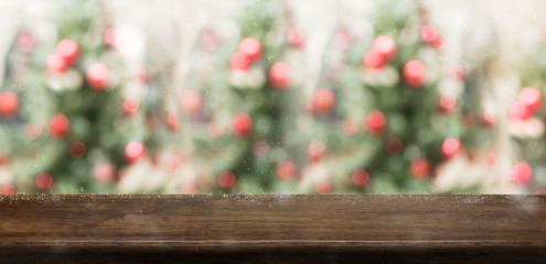 Leinwandbilder - Empty rustic wood table top with abstract blur christmas tree red decor ball and snow fall background with bokeh light,winter Holiday backdrop,Mock up banner for display of product or promotion.