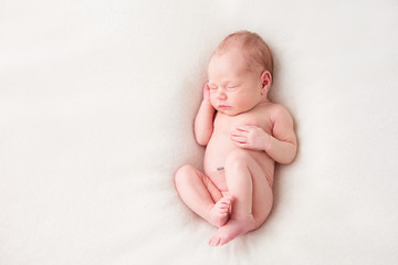 funny newborn baby sleeping peacefully naked. top view