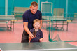 © Alyona - the coach teaches the child to hold the racket correctly for table tennis