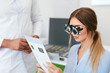 © puhhha - Eye Exam. Woman In Optometry Glasses Reading Eye Test Card