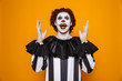 Happy clown looking and raise hands up to copy space