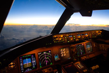 The view from commercial airplane, seen from captain seat in cockpit in the morning twilight during flying above the cloud over the ocean. Modern aviation concept.