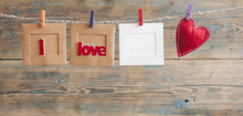 Paper Photo Frame With Written Message Spelling I Love You And Red Hearts Hanging On Rope