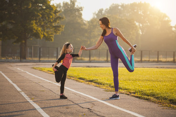  Mama i córka na porannym treningu sportowym rozgrzewają się. Zdrowy tryb życia