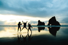 A Group Of People Taking A Photo With With Famous Rocks. Sunset Scene Golden Light And Silhouette. Wharariki Beach Nelson, South Island, New Zealand.