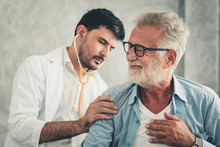Medical Doctor Is Examining Physical Health Of Patient In Examination Room, Physician Doctor Using Stethoscope Diagnosis Disease For Elderly Man While Consulting Medic Treatment. Health Care/Medicine