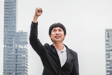 Business man success. Businessman winner. Happy win. Triumph, victory of successful people, person or executive manager in suit. Concept of career. Adult young male, guy smile in city background