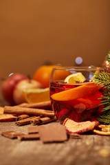 Wall Mural - close up view of tasty mulled wine drink, chocolate and pine tree branch on wooden surface