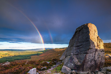 Sticker - Rainbow at Drake Stone / The Drake Stone at Harbottle in Northumberland is a huge 30 feet tall sandstone boulder reputed to have special healing powers