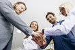© BGStock72 - Closeup of young coworkers putting hands together as symbol of unity in the office