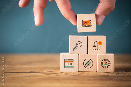 Fotomural Hand stapelt Online-Marketing Komponenten als Symbole auf Würfeln