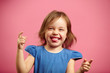 © Ilshat - Portrait of joyful little girl in good mood, bit her tongue, raised hands up.