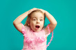 © Ilshat - Scared little girl with open mouth and hands on head