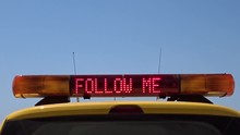 Airport Marshaller Car Displaying A Bright Sign Of FOLLOW ME With Space Left For Text Or Logo. Perfect For Vloggers Or Use In Any Social Network Like Youtube, Facebook, Twitter Or Instagram.