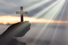Silhouette Of Cross In Human Hand, The Background Is The Sunrise., Concept For Christian, Christianity, Catholic Religion, Divine, Heavenly, Celestial Or God.