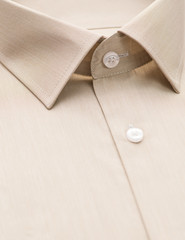 beige shirt with focus on collar and button, close-up