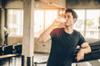 © slonme - Unrecognizable young man in sportswear running on treadmill at gym and holding bottle of water