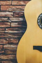 Acoustic Guitar On A Brick Wall Background.