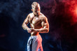© zamuruev - Handsome strong bodybuilder posing in studio on colored smoke background